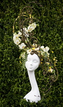 Chelsea Flowershow 2009. Floral arrangement designed by Sarah Horne featuring orchids on sculptural structure placed in turn on white manikin head.