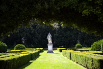 Italy, Tuscany, San Quirico, Val D'Orcia, The 16th Century Horti Leonini formal gardens by Diomede Leoni with view along grass pathway lined by clipped hedging and leading to 1688 statue of Cosimo III...