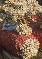 Turkey, Aydin Province, Kusadasi, Bundles of garlic for sale at weekly market.