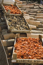 Turkey, Aydin Province, Sirince, Shallow wooden crates of chilies and mushrooms drying in late afternoon summer sunshine on tiled rooftops of house in the old town.