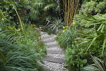 Urban garden with pebble path and railway sleepers. Planting includes Helenium Indian Summer, Echinacea purpurea and Rudbeckia subtomentosa.