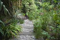 Urban garden with pebble path and railway sleepers. Planting includes Helenium Indian Summer, Echinacea purpurea and Rudbeckia subtomentosa.