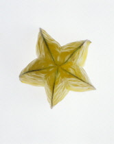 Studio shot of slice of Starfruit showing skin and ridged exterior form.