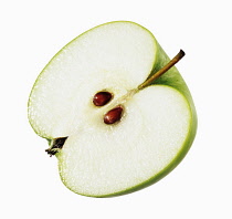 Apple, Malus domestica 'Granny Smith', Cut out on white of half slice of one green apple showing two pips.