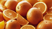 Orange, Citrus sinensis, Several whole fruits, with halves and quarters grouped together.