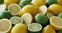 Lemon, Citrus limon and limes, Citrus aurantiifolia, Several whole fruits, with halves grouped together.