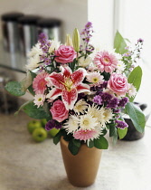 Lily, Lilium 'Star Gazer', Floral Arrangement with pink chrysanthemum, roses and gerberas and purple statice in a vase.