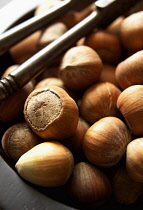 Hazel, Cob-nut, Corylus avellana, Mass of brown coloured nuts next to cracker.