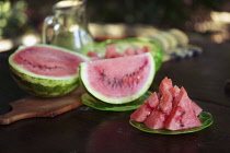 Watermelon, Citrulus lanatus, Outdoor shot of sliced fruit showing red flesh and seeds.