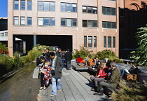 USA, New York, Manhattan, people seated and walking beside the water feature on the Sundeck leading to the Chelsea Market Passage on the High Line linear park on a disused elevated railroad spur calle...