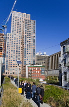 USA, New York, Manhattan, people walking through the Wildflower Field on the High Line linear park on a disused elevated railroad spur called the West Side Line running between high rise buildings in...