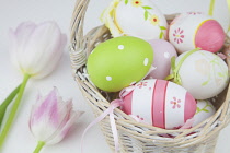 Studio shot of decorated Easter eggs in a wicker basket. Religious Festivals